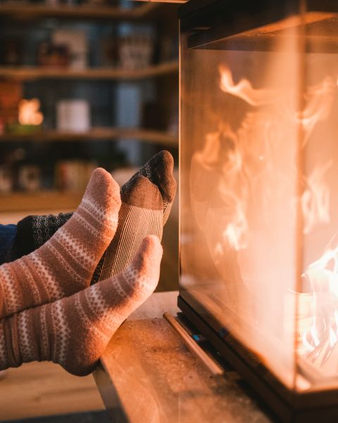 Paar mit Füßen am Kamin