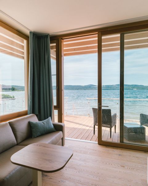 Blick von oben auf eine verschneite, kleine Halbinsel mit Boot