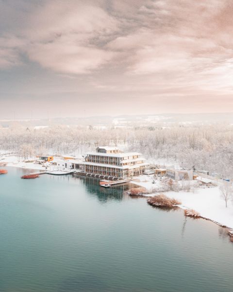 Blick auf das Hotel und den See aus einer Vogelperspektive bei Schnee
