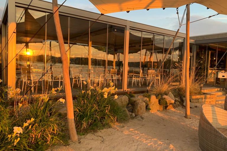 Blick vom Strand auf den Gaspavillon bei Sonnenuntergang