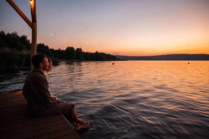 Paar sitzt bei Sonnenuntergang auf dem Steeg 