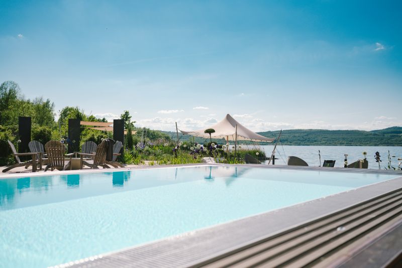 Blick auf den Pool und den See im Wellness Bereich