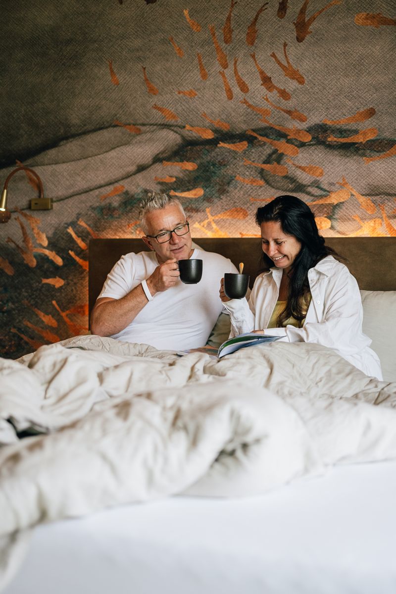 Paar am Morgen im Bett mit Kaffee in der Hand