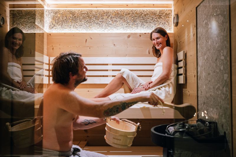 Paar mit Handtüchern in der Sauna einer Ferienwohnung