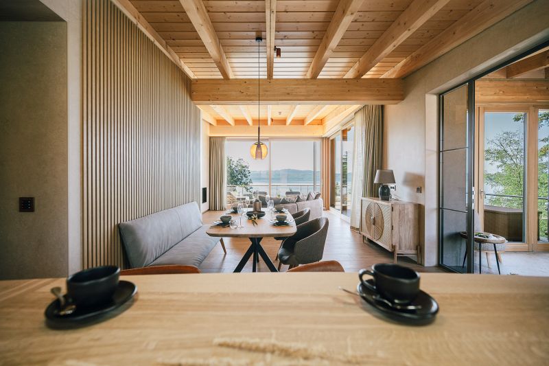 Blick von der Küche über den Essbereich ins Wohnzimmer mit Panoramafenstern im Hintergrund