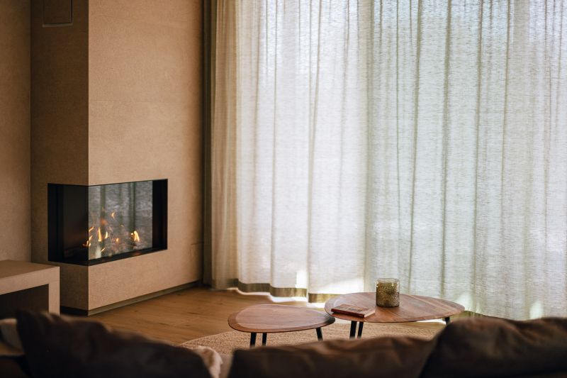 Detailfoto Wohnbereich mit Blick auf den kamin und zugezogenen Vorhängen