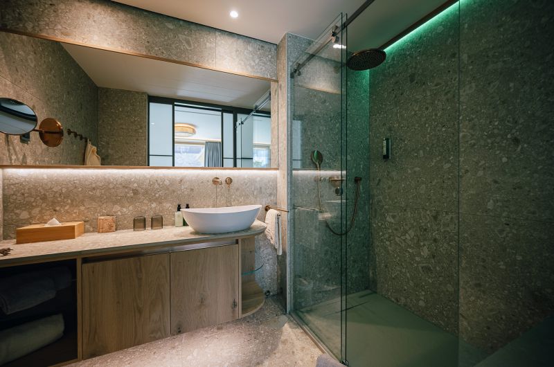 Blick in ein Badezimmer auf Waschbecken und ebenerdige Dusche