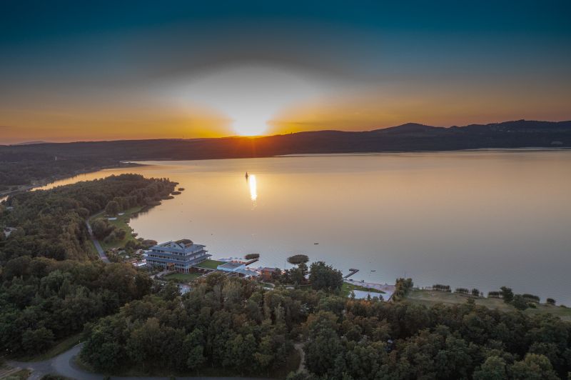 Blick von Oben auf das Hotel und den See bei Sonnenuntergang