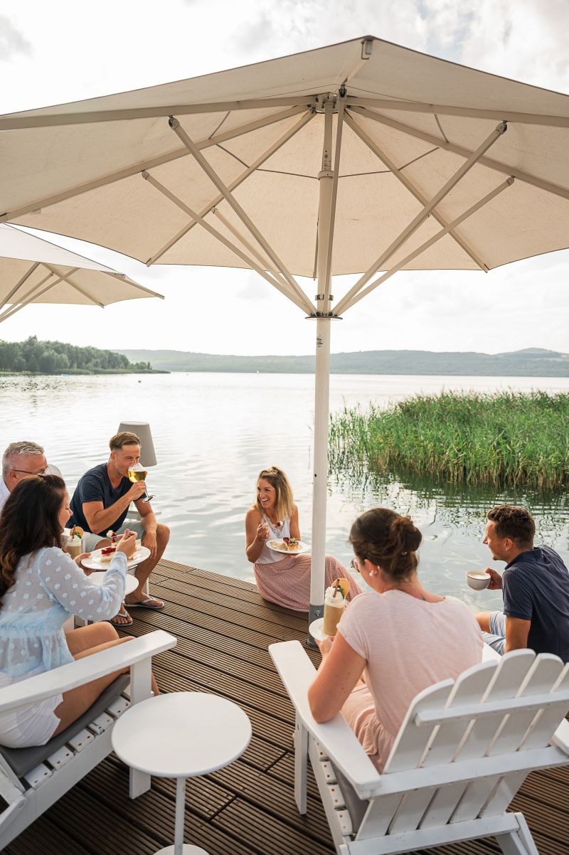 Menschen sitzen gemeinsam auf der Seeterrasse