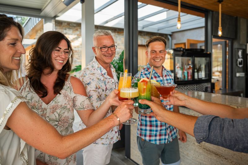 Gruppenfoto beim Anstoßen von Cocktailgläsern