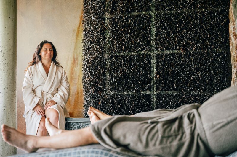 Dame sitzt neben dem Gradierwerk in dem Ruheraum 'Raum des Wassers' 