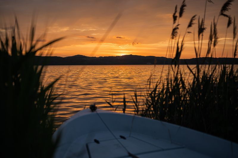 Blick auf den Sonnenuntergang von einem Boot was im Schilf steht