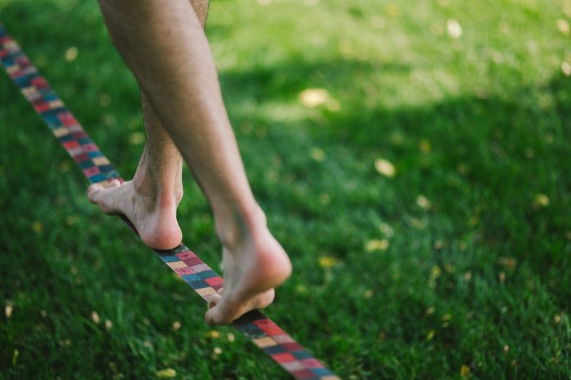 Eine Person läuft auf der Slackline auf dem Sportstrand