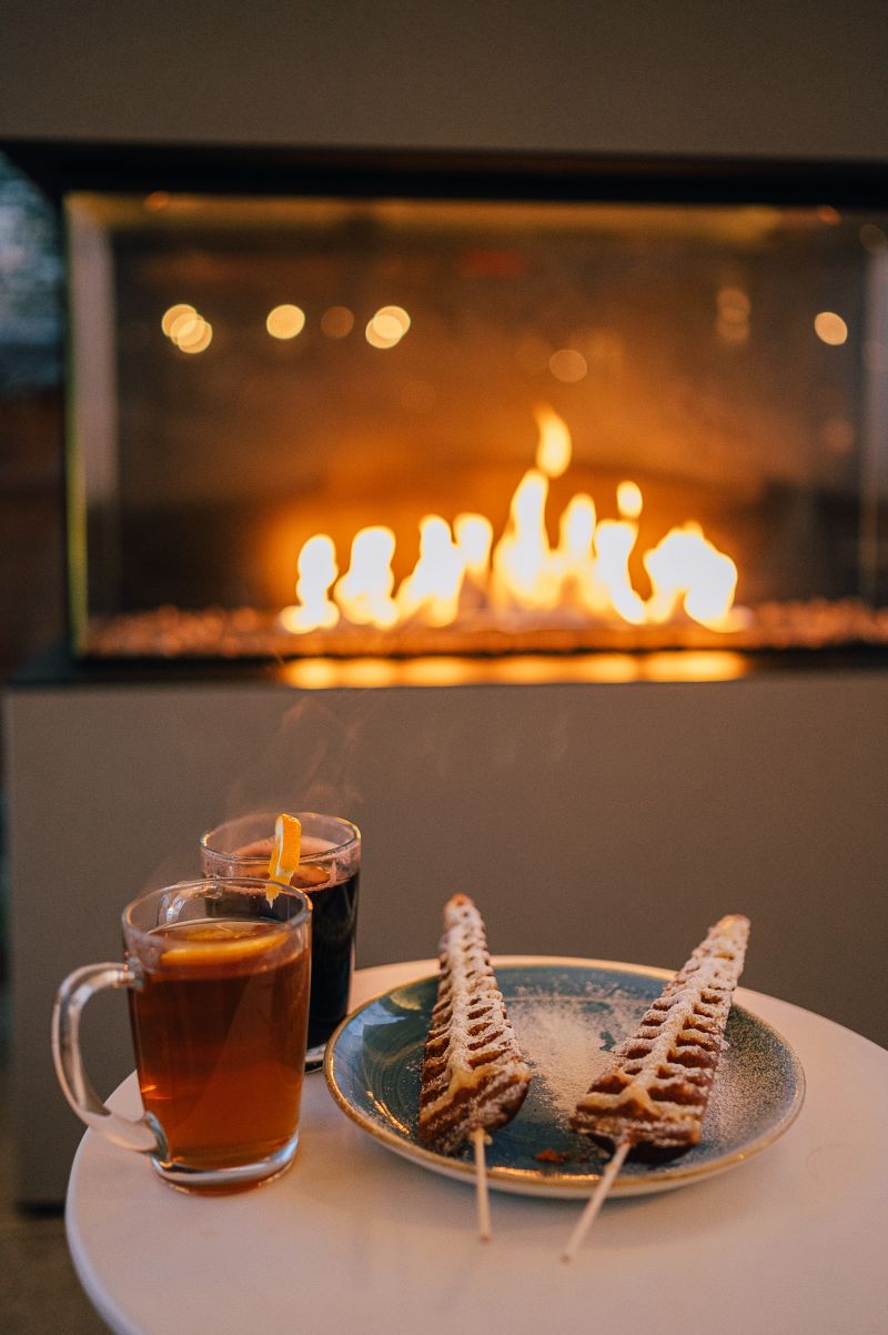 Waffeln und Glühwein auf dem Tisch vor einem Kamin