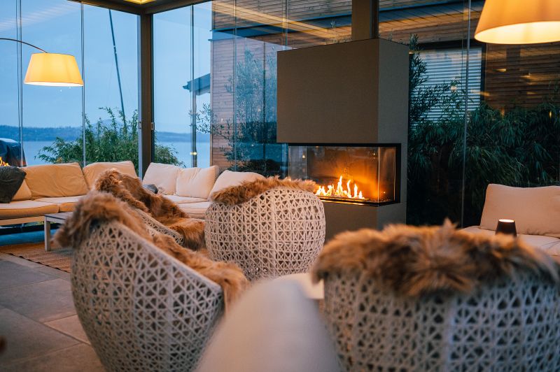 Blick zum brennenden Kaminfeuer im Glaspavillon