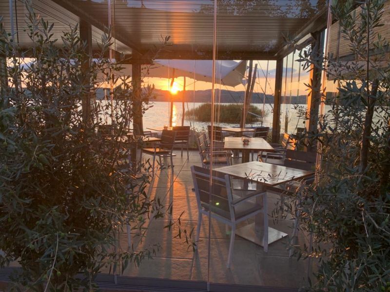 Blick durch den Glaspavillon Richtung Sonnenuntergang