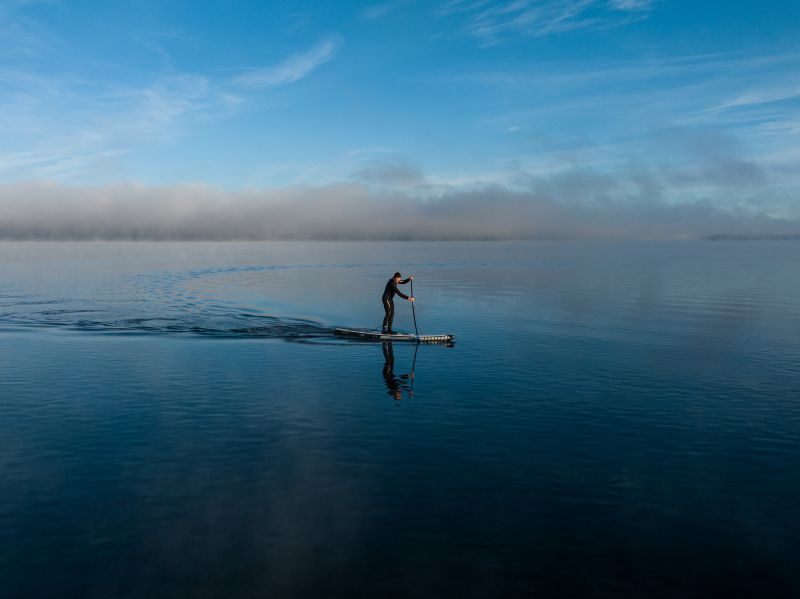 Mann auf dem SUP auf dem See
