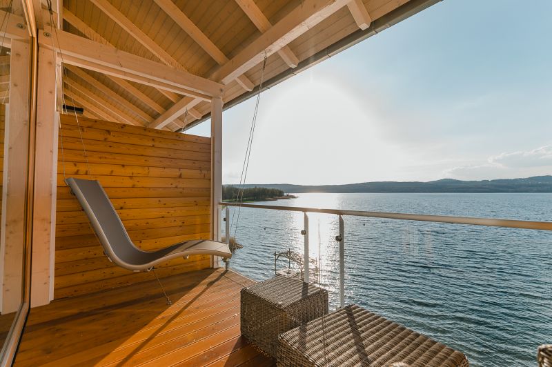 Blick auf eine Hängeliege und den See in einer wellnes Junior Suite