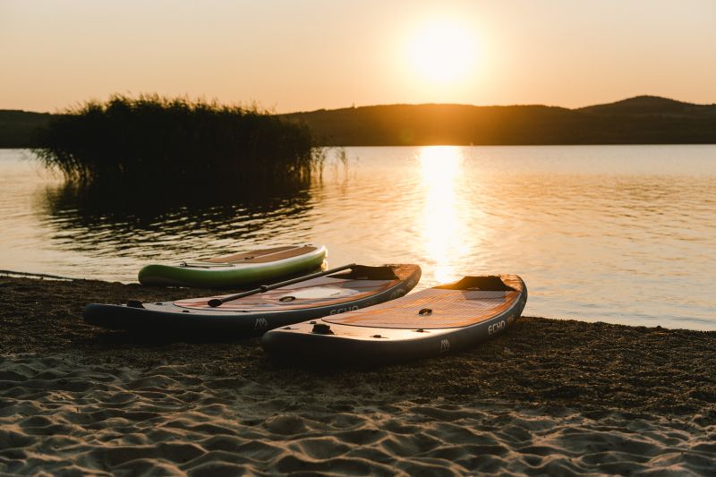 SUP Boards am Strand bei Sonnenuntergang