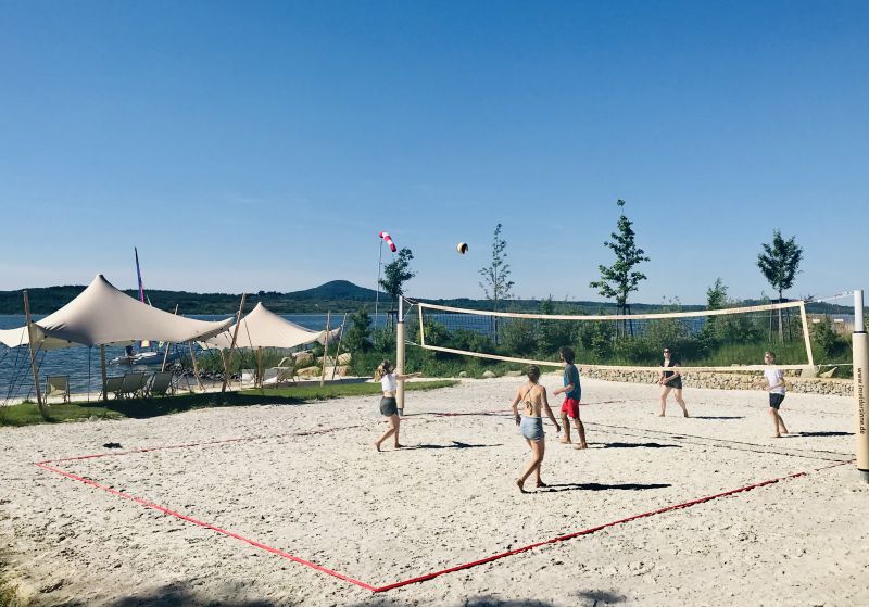Gruppe spielt Beachvolleyball am Sportstrand